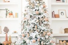 a beautiful flocked Christmas tree with ribbons, grey and copper metallic ornaments with a star topper