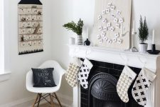 a black letter banner, a black and white advent calendar, black and white printed stockings and black candleholders with white candles