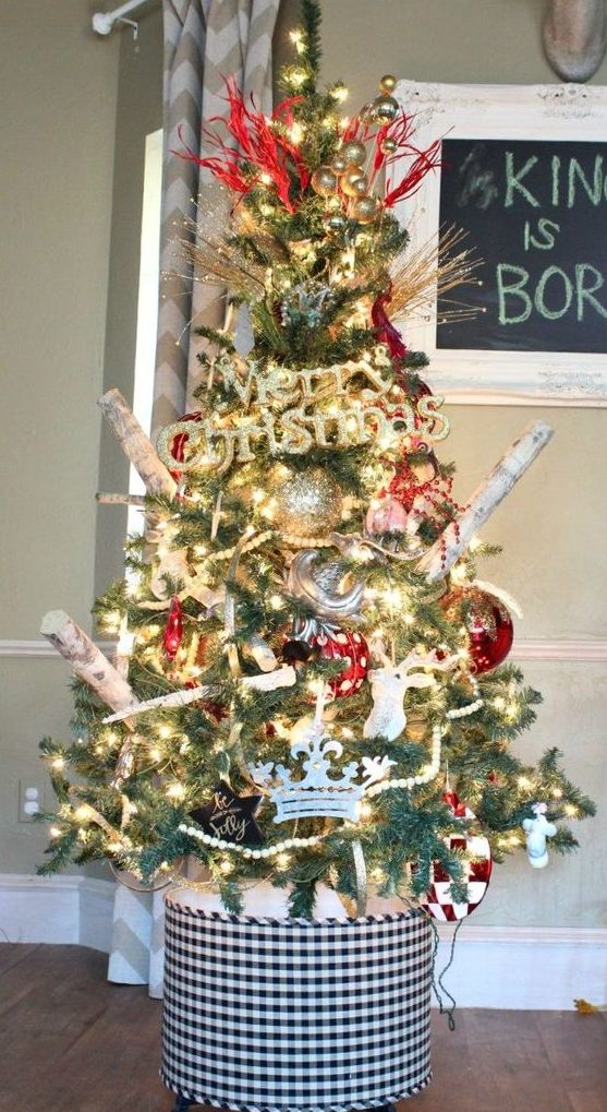 A bright rustic Christmas tree with lights, branches, plaid and polka dot ornaments and metallic ones, too plus a plaid