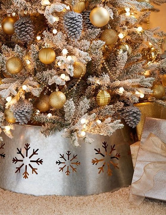 a galvanized metal tree collar with laser cut snowflakes is a great finishing touch for your tree