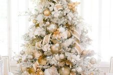 a glam flocked Christmas tree with oversized metallic ornaments, ribbons, branches and some faux blooms is amazing