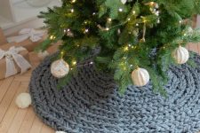 a lovely and casual Christmas tree skirt of grey chunky knit with white pompoms that echo with the baubles