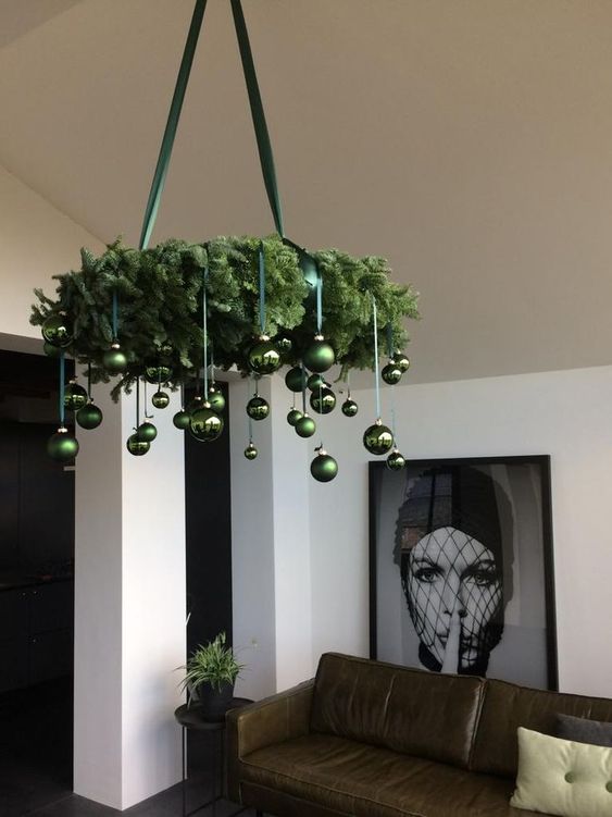 a pretty modern evergreen Christmas chandelier with green ornaments is a stylish and bold decoration to rock