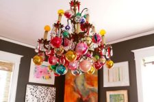 a regular chandelier completely covered with colorful ornaments is a stylsih and catchy idea for the holidays