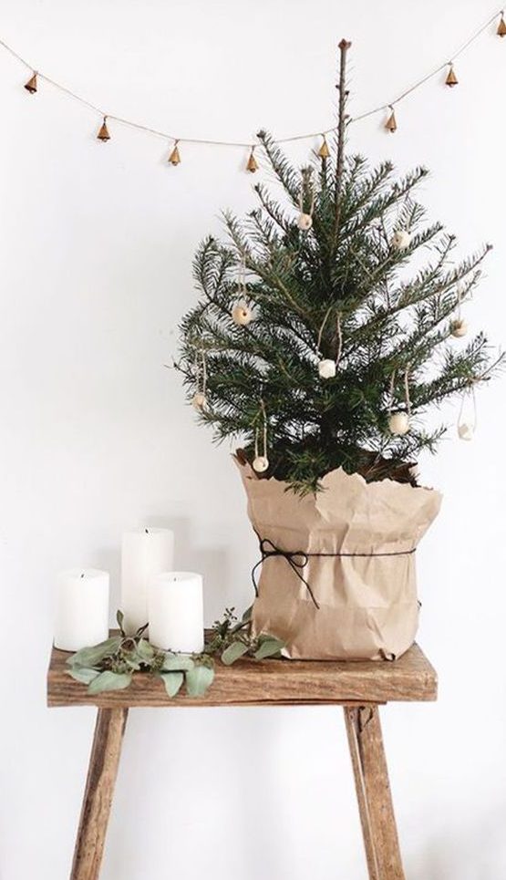 a small Nordic Christmas tree with wooden bead ornaments and a kraft paper cover is a pretty and nice idea with a natural feel
