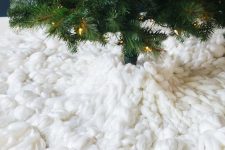 a thick wool tree skirt with huge braided tassels is a stunning and bold idea for a boho Christmas tree