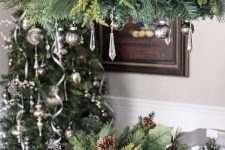 a vintage-inspired Christmas chandelier with evergreens, silver ornaments and crystals is a stylish and cool idea to rock