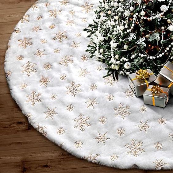 a white Christmas tree skirt with gold embroidery is a cool and catchy decoration for an elegant tree