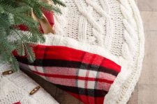 a white braided knit Christmas tree skirt with bold red plaid lining is a chic and cool idea for a traditional Christmas tree