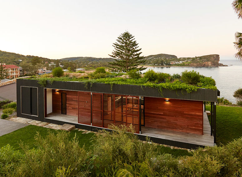 The green roof insulates the home while visually integrating it into the cliff