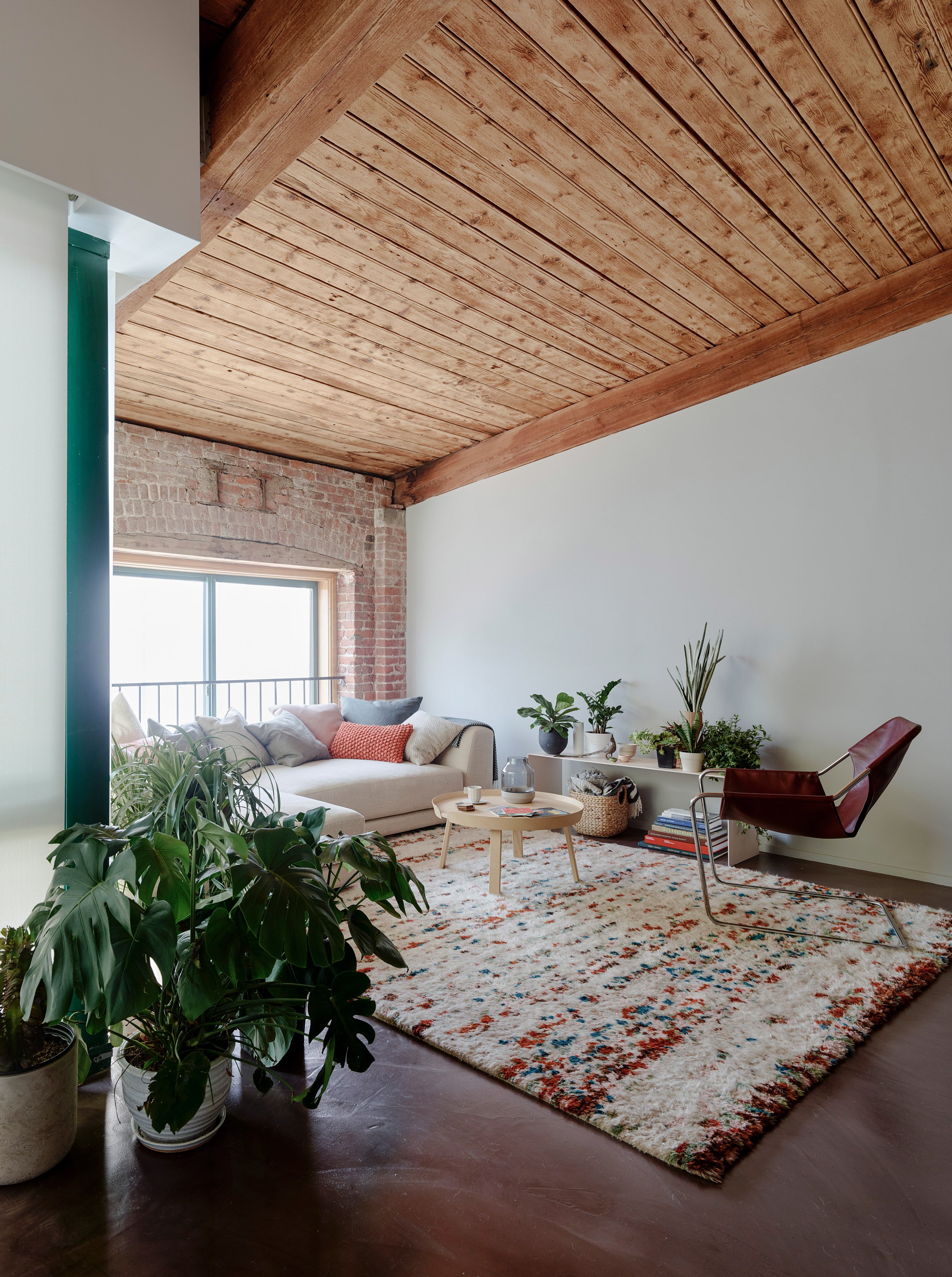 The designers saved and highlighted the original features like a brick clad or wooden beams in this living room