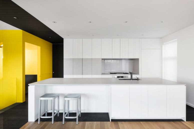 The kitchen is pure white, all the handles and most of appliances are hidden to keep the look minimalist