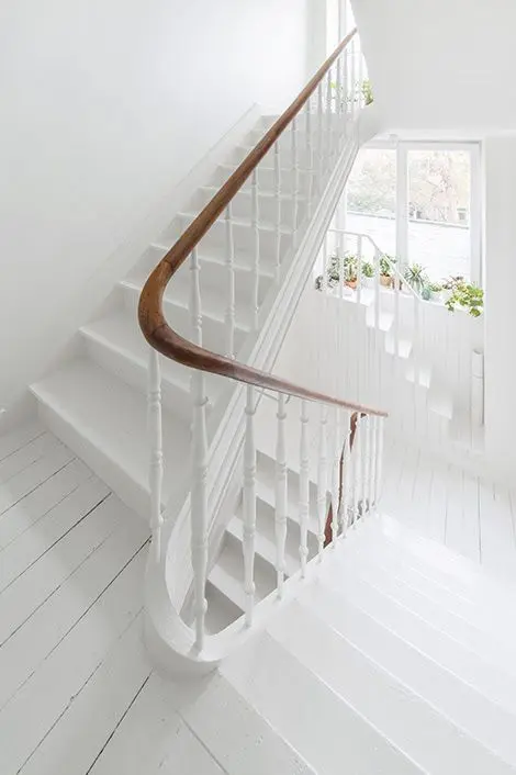 clean white staircase for a shabby chic feel and warm wooden handrail