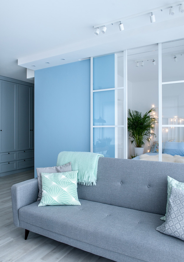 The storage space was made in closed pale blue wardrobes and cabinets to avoid cluttering the space
