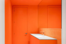 05 One of the bathrooms features bright orange and penny tiles, the space looks very bold