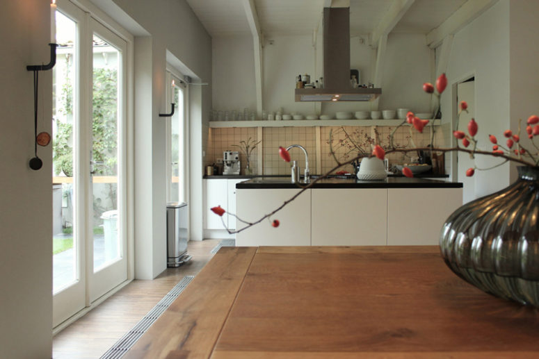 The kitchen is a modern one, with black and white cabinets and open shelving for an airy look