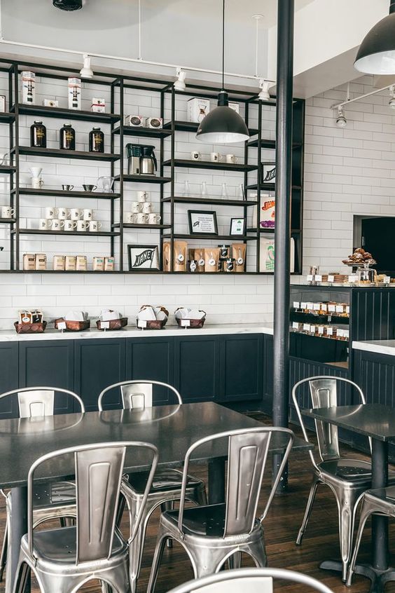 industrial-styled coffee shop with metal furniture and dark metal shelves