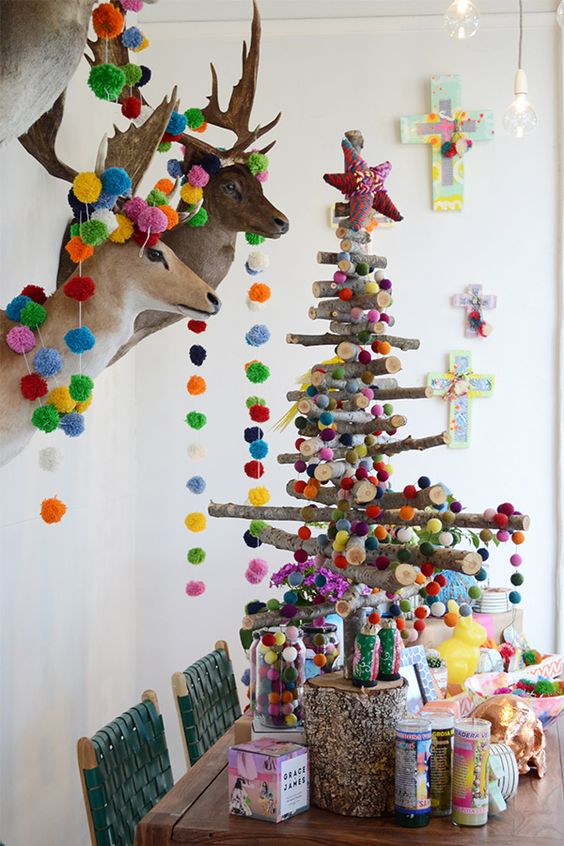stick Christmas tree and taxidermy decorated with colorful pompoms