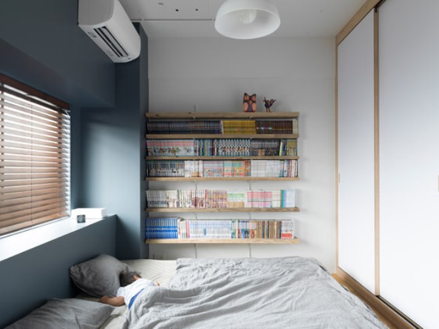 The bedroom is small and simple, with shelves and a covered window for comfortable daytime sleep