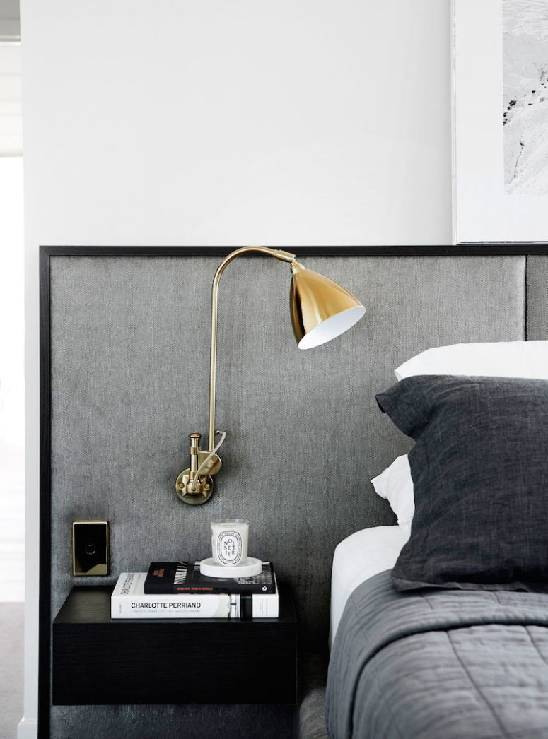 The oversized headboard has attached side tables and sconces