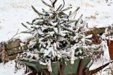 07 a snowy tree in a garden cart is a cute idea and looks natural