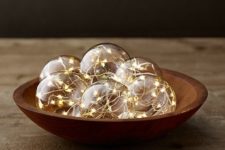 07 a wooden bowl with glass globes with string lights inside