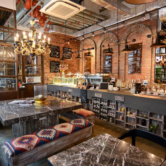 industrial interior is done with exposed pipes and brick walls, upholstered benches make it cozier