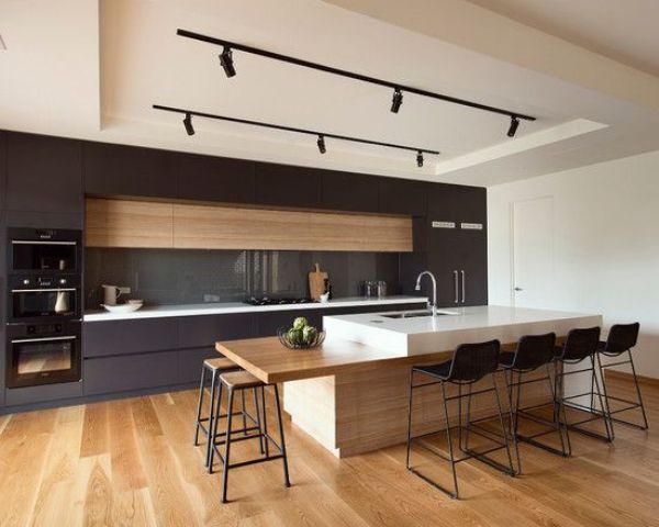 minimalist kitchen with track lights over the kitchen island and counter