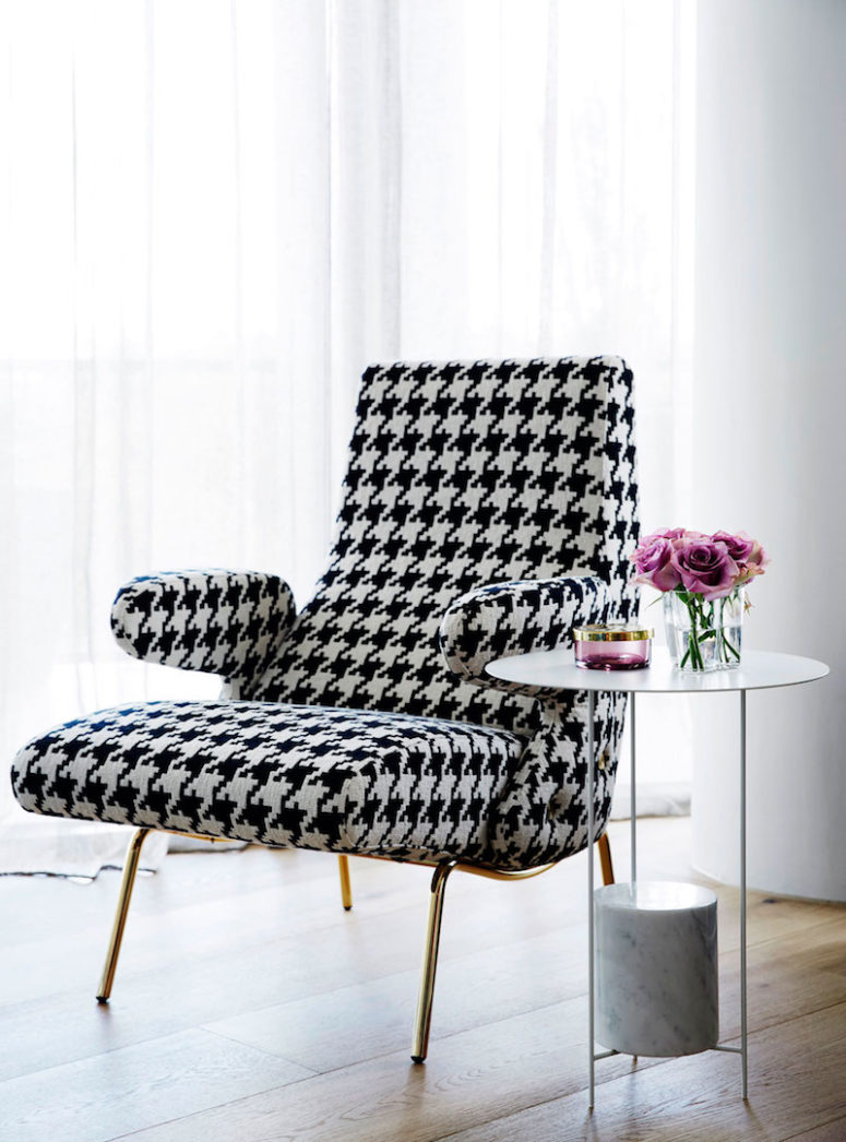 Glam accents can be seen throughout the apartment, such as this chic patterned chair