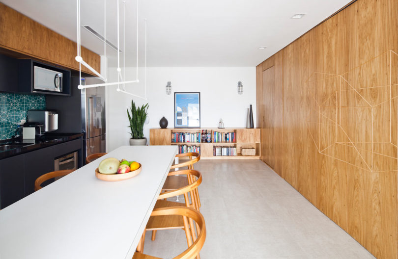 The kitchen is rather spacious, with bookshelves that echoes with a wooden panel