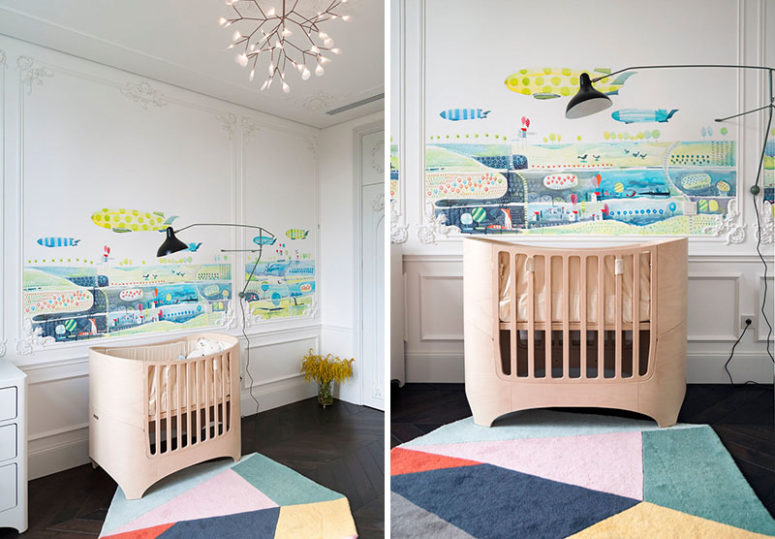 The nursery boasts of unique watercolor wall art over the crib