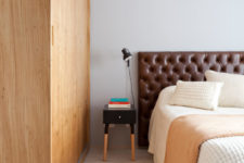 09 The bedroom has simple and cozy design, with a warm wood wardrobe, a leather headboard and warm-colored touches