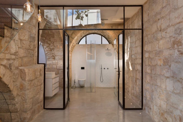 The bathroom also has frosted glass doors and the focal point is the original stone walls
