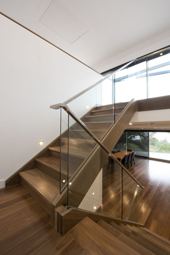modern staircase with a glass balustrade and wooden handrails for a contrast