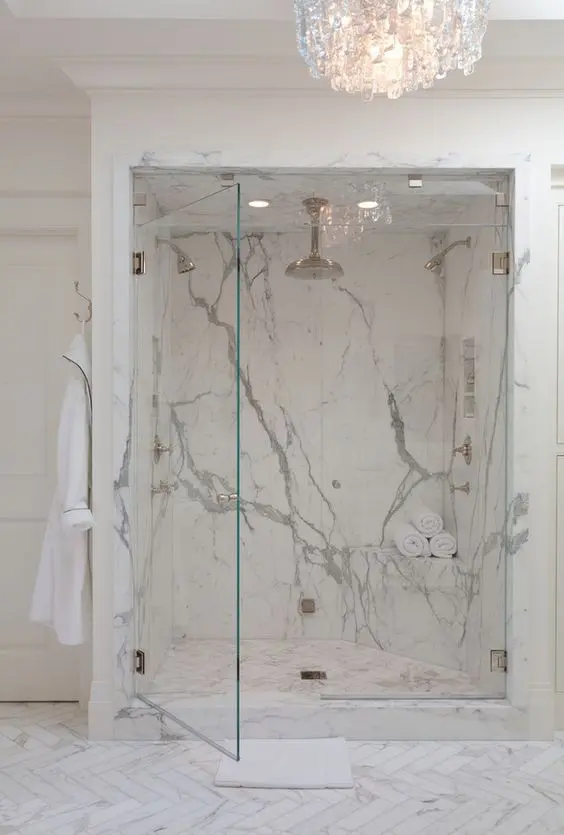 luxurious marble shower and a large crystal chandelier