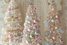 11 pastel and metallic Christmas trees all decorated with beads and small ornaments