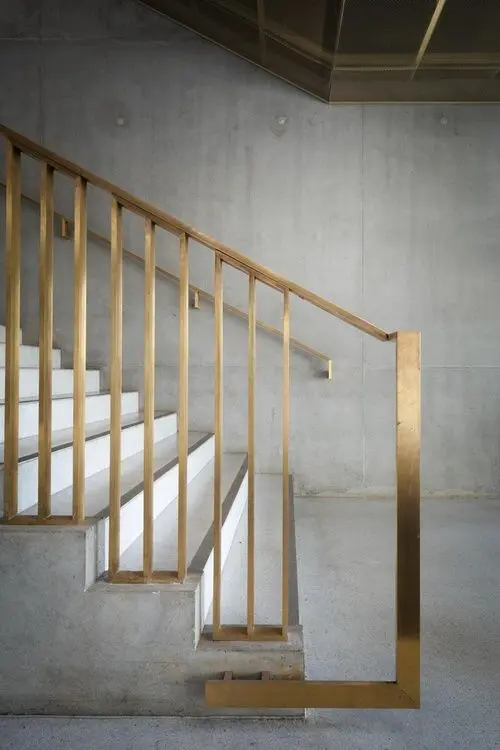 gold metallic banister on a concrete staircase look modern and chic