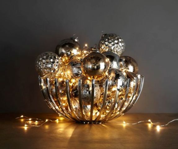 modern bowl filled with metallic ornaments and lights