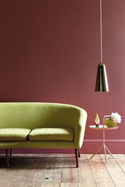 a lime green sofa looks outstanding and fresh against a burgundy wall