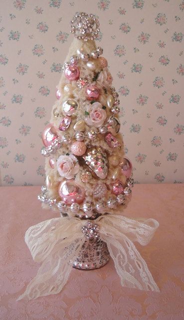 tabletop glossy ornament Christmas tree with jewelry and a lace bow