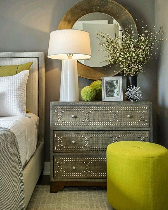 a neutral bedroom can be spruced up with greenery pillows and ottomans