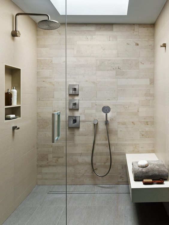 Modern warm colored shower and steam room with a comfy bench