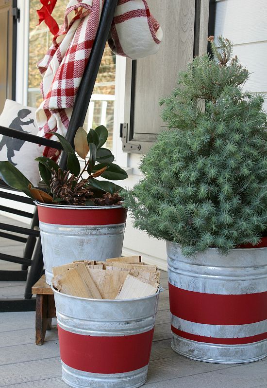 aged red stripe galvanized buckets with wood, greenery and an evergreen tree