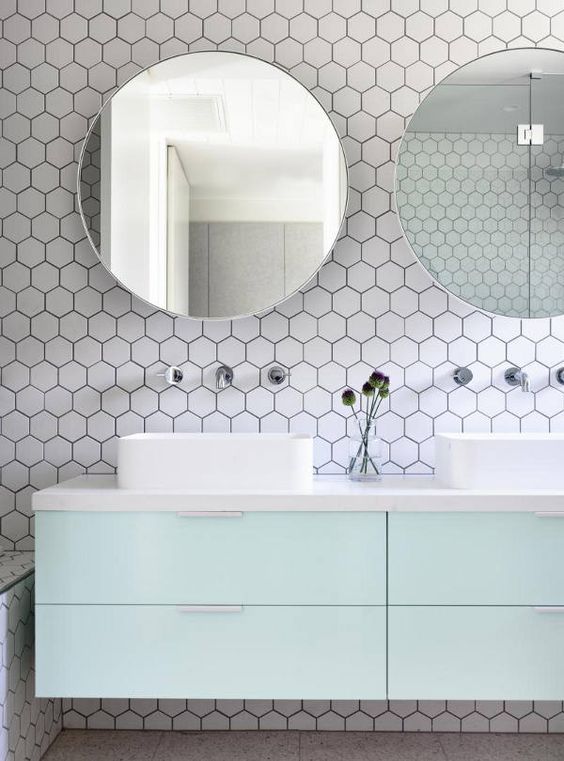 white hex tiles with black grout contrast with mint cabinets