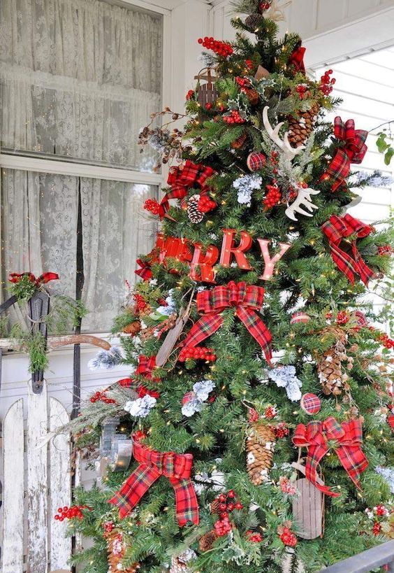 large rustic tree with plaid bows, letters, pinecones and antlers