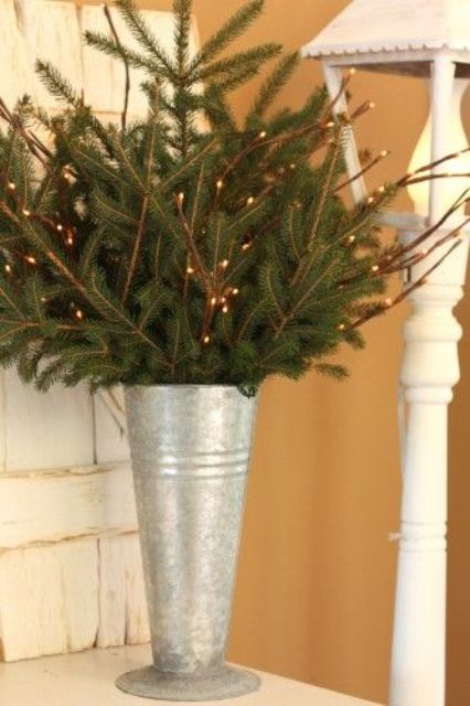 galvanized bucket with evergreen and light branches