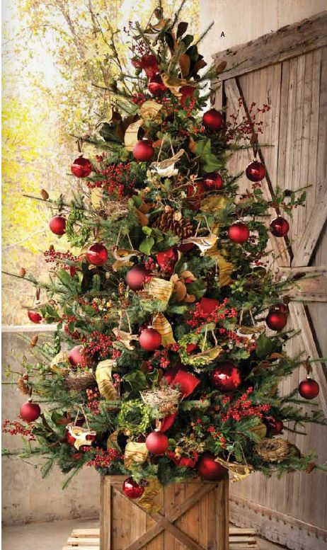 lush tree in a box with red ornaments, gold and green deco mesh and garlands