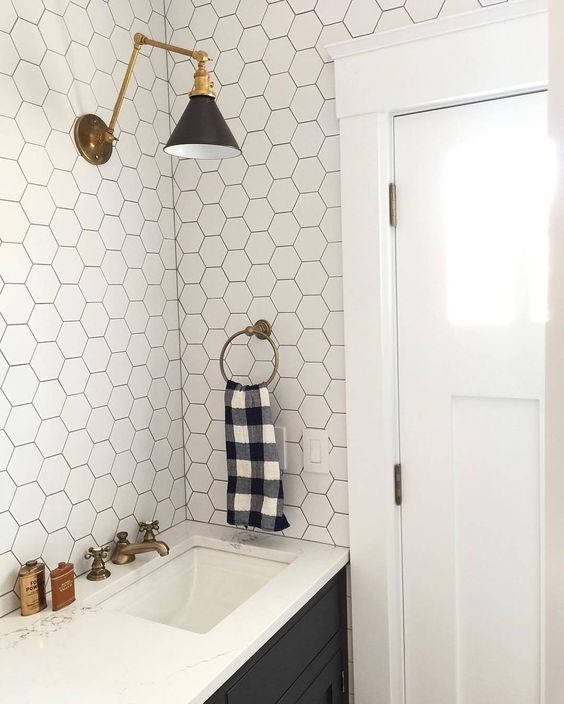 white hexagonal tiles with black grout and black cabinets