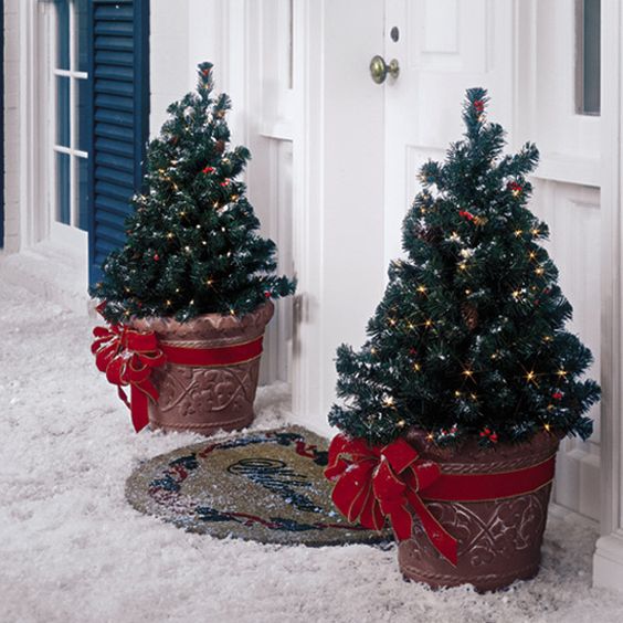 mini potted trees with lights and large red bows