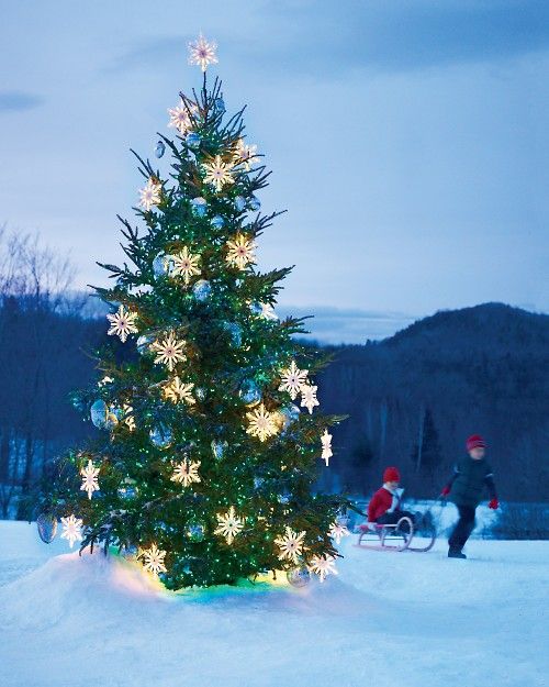 outdoor Christmas tree with light snowflakes and oversized blue ornaments